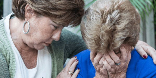 Daughter comforting mother about Alzheimer's care